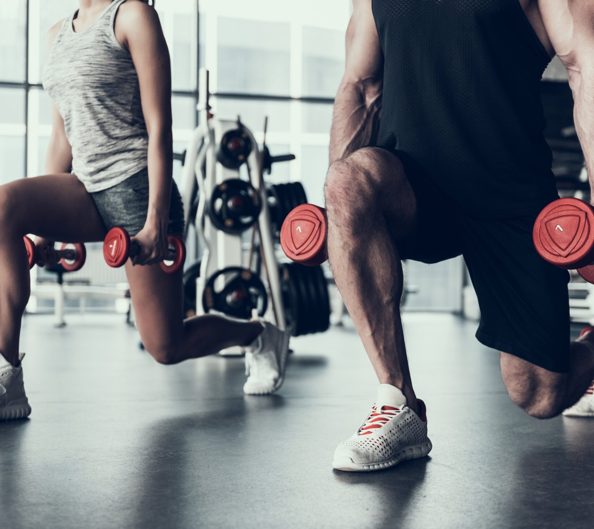 Close up. Man and Woman Training in Fitness Club. Man with Athletic Body. Healthy Lifestyle and Sport Concepts. Young Woman in Training Club. Active Indoor Training. Sport Equipment in Club.